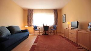 a living room with a couch and a table with chairs at Friends Hotel Kerpen in Kerpen