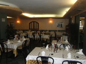 a restaurant with tables and chairs with white table cloth at Hotel Berlinghera in Sorico