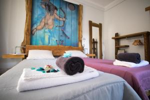 a bedroom with two beds with towels and a painting at Modern & Recycled Guest House in Machico