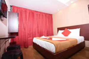 um quarto com uma cama com uma cortina vermelha em HOTEL BOOPATHI Madurai em Madurai