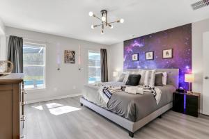 a bedroom with a large bed with a purple wall at Palm Daydreams in Davenport +37 photos