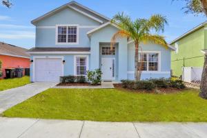 a white house with a palm tree in a yard at Palm Daydreams in Davenport