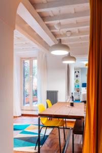 a dining room with a wooden table and yellow chairs at Restart Accommodations Lante e Caffarella in Rome
