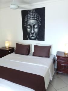 a bedroom with a large bed with a statue on the wall at Nusa Lembongan Villa Shambala in Nusa Lembongan