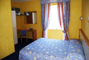 sypialnia z niebieskim łóżkiem i oknem w obiekcie Hotel Beata Giovannina w mieście Verbania