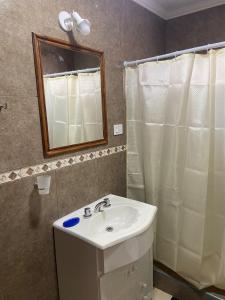 a bathroom with a sink and a mirror and a shower at Departamento en Ramallo in Ramallo +10 photos