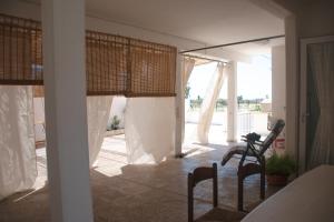 a room with white curtains and a table and chairs at Casa tu Nonnu in Ugento