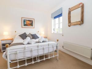 a bedroom with a white bed and a mirror at Meadow View in Truro