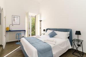 a bedroom with a blue and white bed and a window at SiSTO18 in Catania