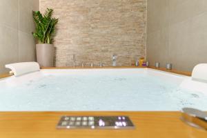a jacuzzi tub with a remote control in a room at SiSTO18 in Catania