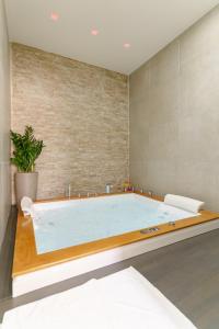 a large bath tub in a room with a wall at SiSTO18 in Catania