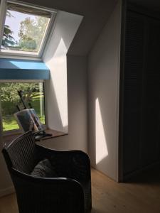 - un salon avec une chaise et une fenêtre dans l'établissement Nature, Mer, Golf & Decouvertes..., à Plouha