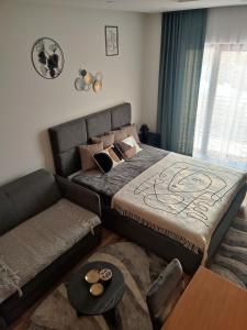 ein Schlafzimmer mit einem großen Bett und einem Sofa in der Unterkunft NLux46 Milmari in Kopaonik