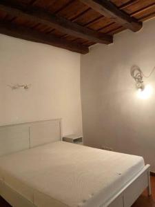 Un dormitorio con una cama blanca con una luz en la pared en Meraviglioso appartamento fronte lago, en Bissone