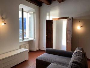 - un salon avec un canapé et une fenêtre dans l'établissement Meraviglioso appartamento fronte lago, à Bissone