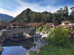 eine Brücke über einen Teich mit einem Berg im Hintergrund in der Unterkunft Aranwa Sacred Valley Hotel & Wellness in Urubamba