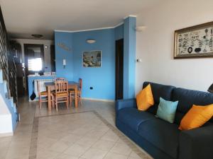 sala de estar con sofá azul y mesa en A casa di Rita, en Surbo
