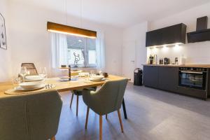 a kitchen with a wooden table and chairs in a room at Q-FLATS Bochum-Hamme - verkehrsgünstig und komfortabel in Bochum
