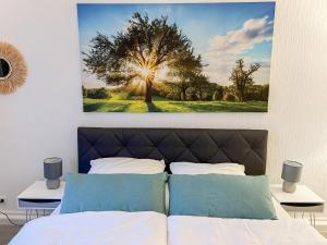 a bedroom with a tree painting on the wall at Q-FLATS Bochum-Hamme - verkehrsgünstig und komfortabel in Bochum