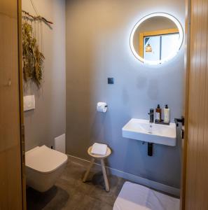 een badkamer met een toilet, een wastafel en een spiegel bij PORTAL Village Only Adults in Sibiel
