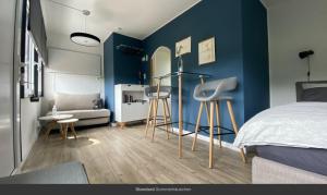 - une chambre aux murs bleus avec un lit et des tabourets dans l'établissement Sommerhäuschen, à Rheinsberg