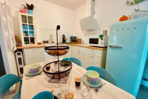 a kitchen with a table with chairs and a blue refrigerator at Escapade au Soleil B002 in Le Grau-du-Roi