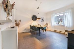 a dining room with a table and a clock on the wall at Q-FLATS Bochum-Hamme - verkehrsgünstig und komfortabel in Bochum +21 photos