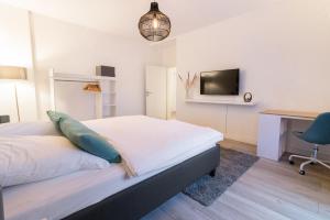 a bedroom with a bed and a desk and a tv at Q-FLATS Bochum-Hamme - verkehrsgünstig und komfortabel in Bochum