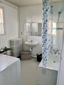 Baño blanco con bañera y lavamanos en Le temps du Loing en Nemours