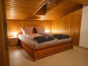 1 dormitorio con 1 cama en una habitación de madera en Ferienwohnungen Ebensperger - Chiemgau Karte en Inzell