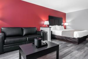 Econolodge Inn & Suites St-Apollinaire في Saint-Apollinaire: غرفه فندقيه بسرير واريكه