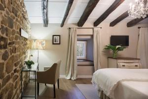 a bedroom with a bed and a table and a window at Posada Casa Guadamillas 