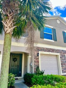 a house with a palm tree in front of it at A Cozy Home Away From Home in Riverview