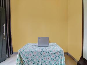 einen Laptop auf einem Tisch im Zimmer in der Unterkunft SPOT ON 92255 Lucky Guesthouse in Kubang