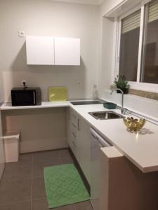 a white kitchen with a sink and a microwave at Romantic and Bright Studio Apartment in Arroios - SSL 2B in Lisbon