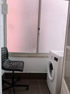 La salle de bains est pourvue d'une chaise et d'un lave-linge. dans l'établissement Romantic and Bright Studio Apartment in Arroios - SSL 2B, à Lisbonne