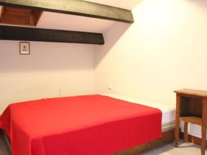 uma cama vermelha num quarto com uma mesa em Appartement Port-la-Nouvelle, 1 pièce, 4 personnes - FR-1-229C-181 em Port-la-Nouvelle
