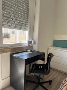 a desk with a chair in a room with a window at Romantic and Bright Studio Apartment in Arroios - SSL 2B in Lisbon