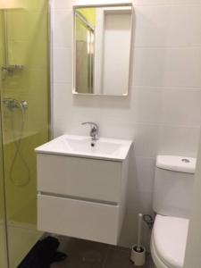 a bathroom with a sink and a toilet and a mirror at Romantic and Bright Studio Apartment in Arroios - SSL 2B in Lisbon