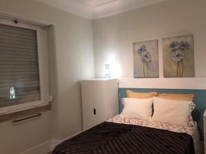 a bedroom with a bed with two paintings on the wall at Romantic and Bright Studio Apartment in Arroios - SSL 2B in Lisbon