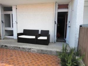 um sofá preto sentado no alpendre de uma casa em Maison Port-la-Nouvelle, 3 pièces, 6 personnes - FR-1-229C-7 em Port-la-Nouvelle
