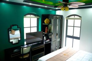 um quarto com paredes verdes, uma cama e um espelho em THE SEA HOTEL 14 em Ha Long