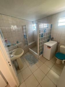 La salle de bains est pourvue d'un lavabo, de toilettes et d'une douche. dans l'établissement Chez Maïté, à Terre-de-Bas