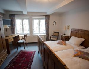 a hotel room with two beds and a desk and a desk at Gasthof Averbeck in Ennigerloh