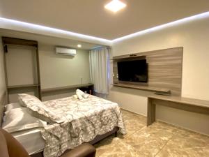 een slaapkamer met een bed en een flatscreen-tv bij O Canto Pousada in Piranhas