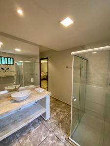 a bathroom with a sink and a glass shower at O Canto Pousada in Piranhas