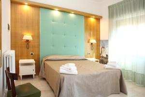 a bedroom with a bed with towels on it at Albergo Russo in Trapani