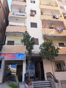 a tall white building with stairs in front of it at Sweet Home Flat 2 in Hurghada
