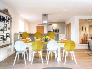 a kitchen with yellow and white chairs in a room at Hayloft in Lincoln