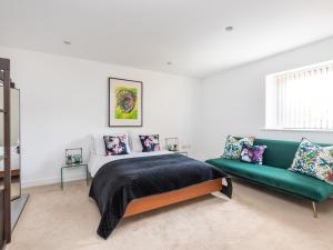 a bedroom with a bed and a green couch at Hayloft in Lincoln